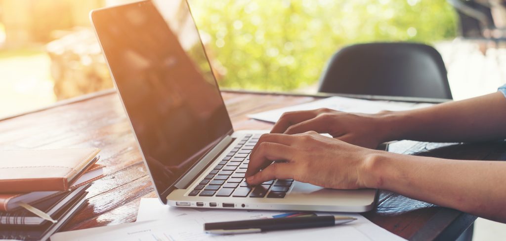 Business woman hand typing on laptop keyboard