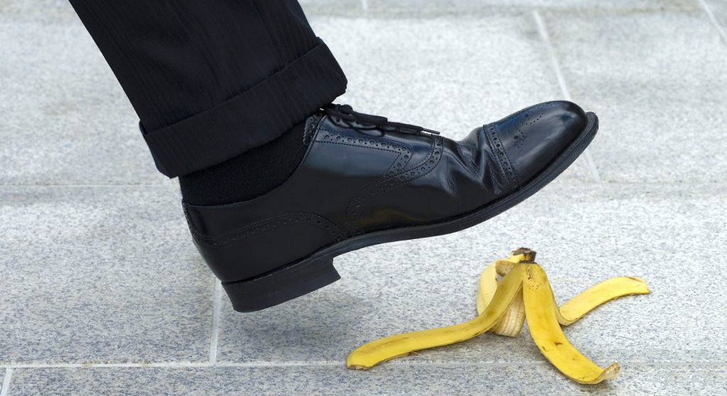 Businessman stepping on banana skin