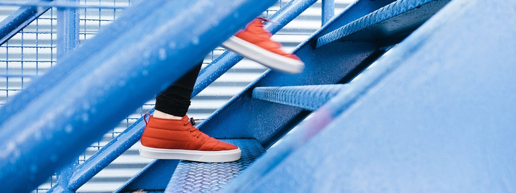 Close up of sneakers climbing up stairs.