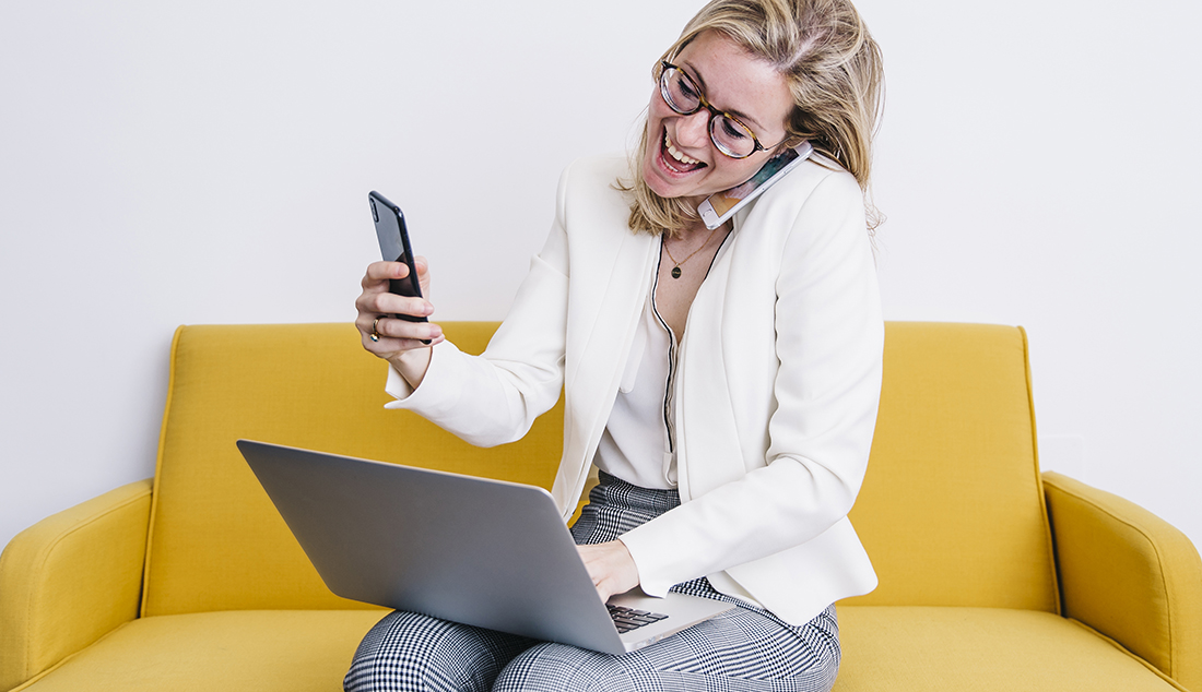 Woman holding several phones and smiling - business reference