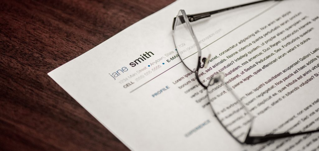 Close up a eyeglasses sitting atop a resume