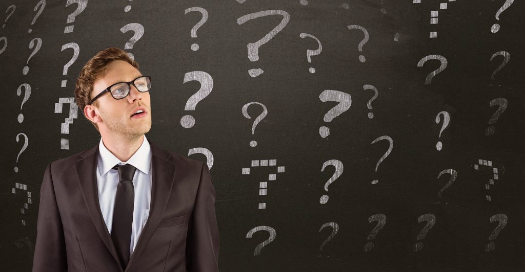 Thoughtful man with question symbols behind