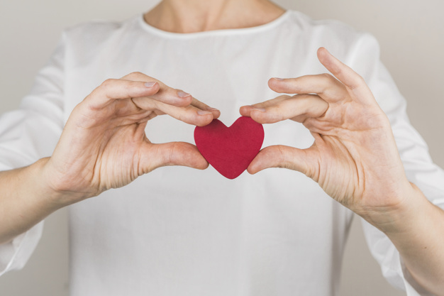 Close up of a person holding a red heart