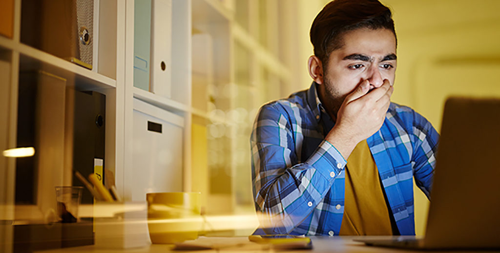 Worried guy covering mouth by hand while looking at laptop display and understanding that dangerous virus attacked his computer