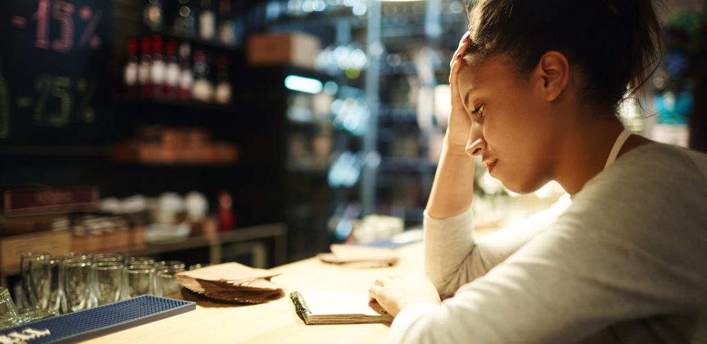 Tired waitress reading notes at the end of working day