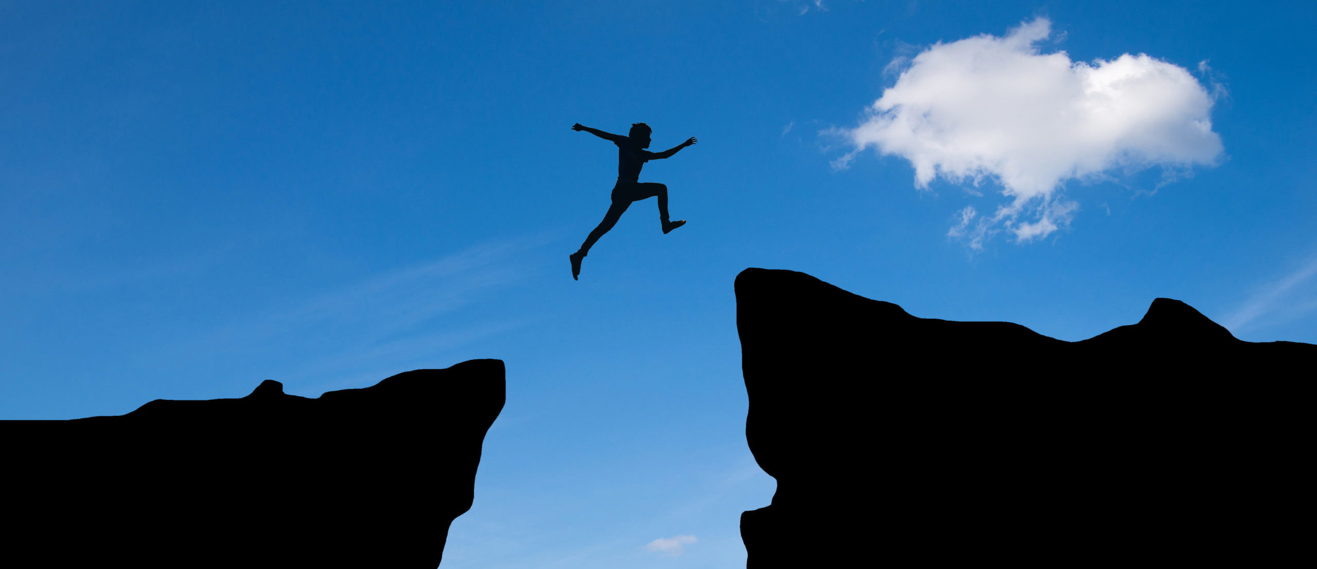 Man jump through the gap between hills