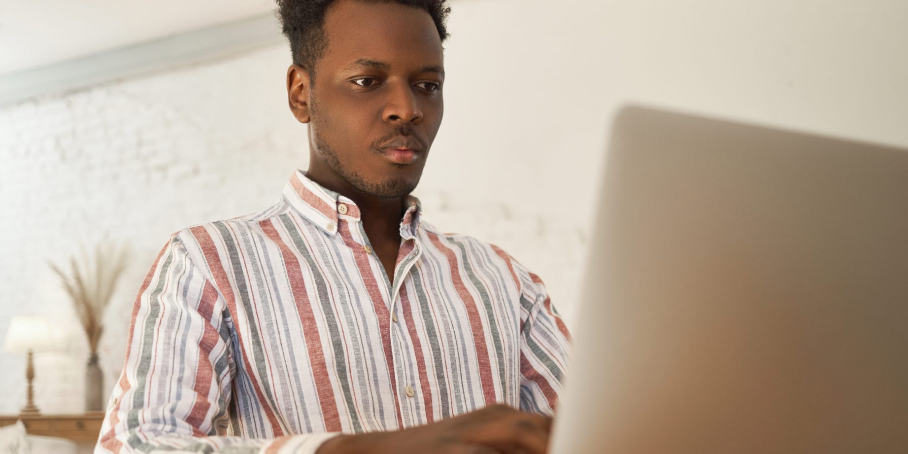 Focused young african male applying for jobs online