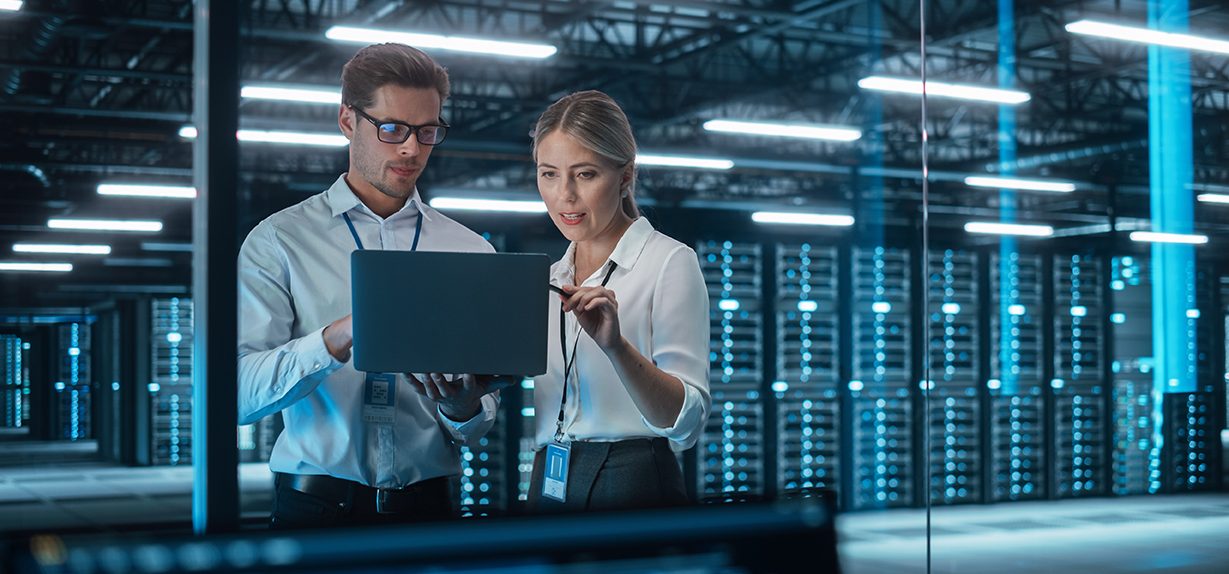 Man and woman working together in IT data centre.