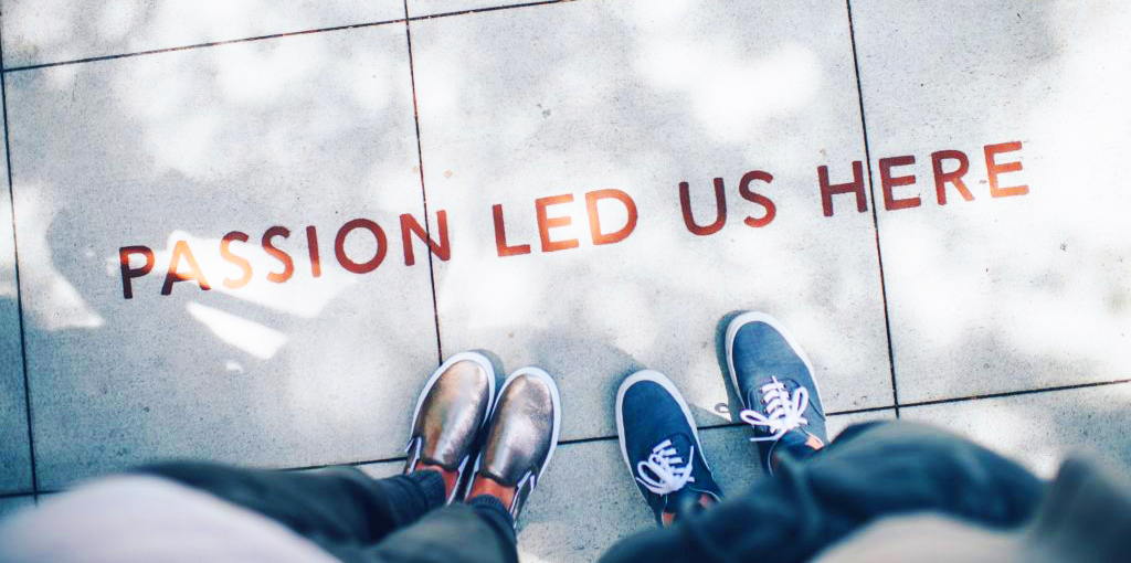 2 people standing on a sidewalk engraved with the words "Passion Led Us Here."