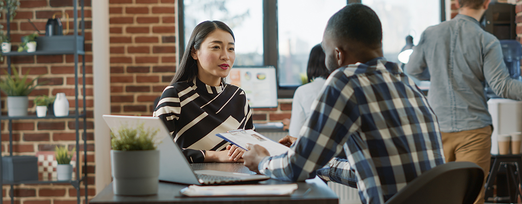 Male recruiter interviewing job seeker about work experience, making employment offer. Man and woman meeting to discuss about HR recruitment, analyzing resume information to hire.