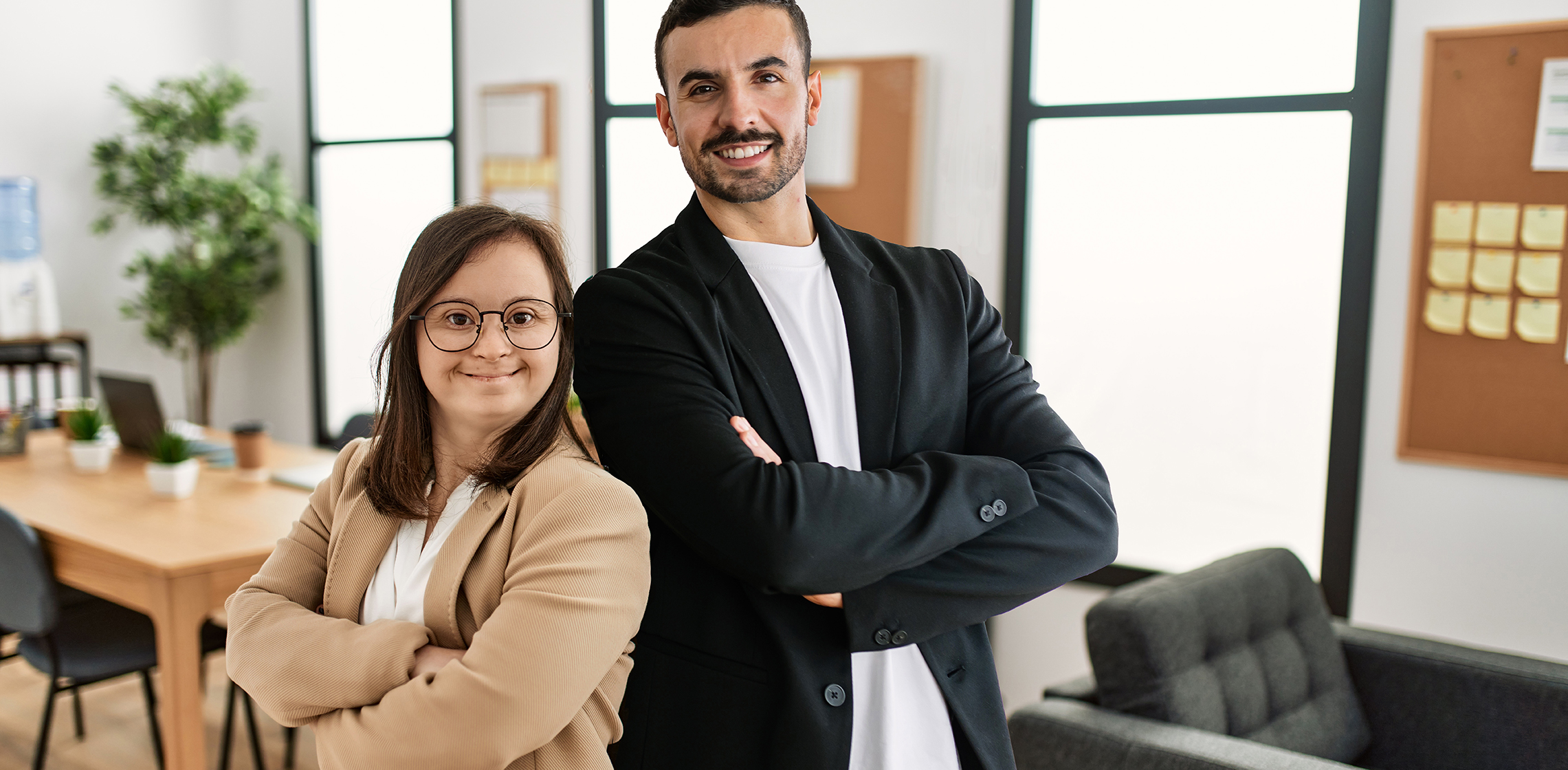 Group of two women working at the office. Mature woman and down syndrome woman working at inclusive teamwork.